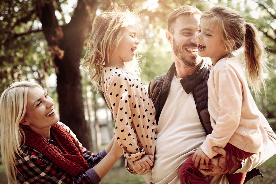 Personal Insurance - Cheerful Family Together in Park Enjoying Outdoors